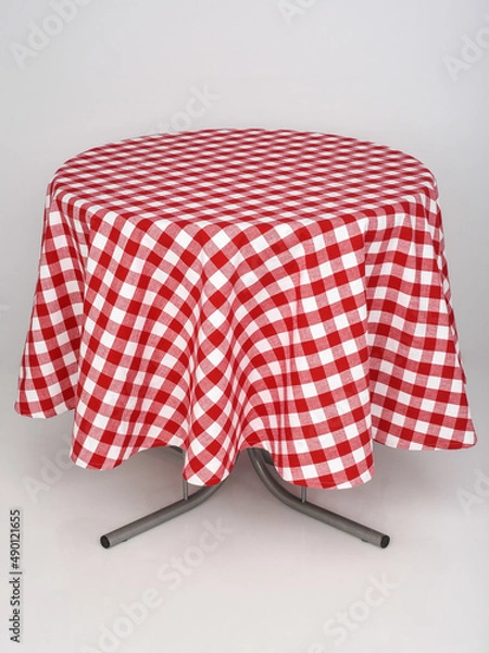 Fototapeta red checkered tablecloth spread out on a round table on a white background