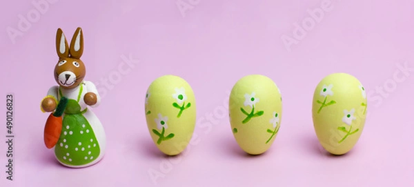 Obraz Easter mom rabbit and three eggs on a pink background