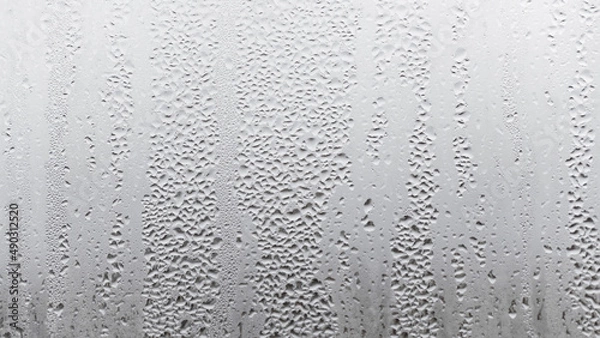 Fototapeta Texture of the rain on the glass, steamy window with water drops made in dull day