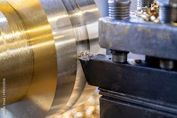 Fototapeta The work of a lathe in the production of non-ferrous metal products. Soft focus