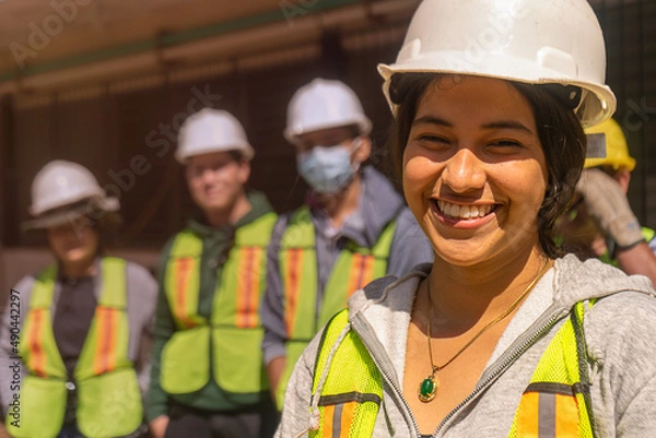 Fototapeta Empowered young woman, engineering student in front of a group of students and professionals