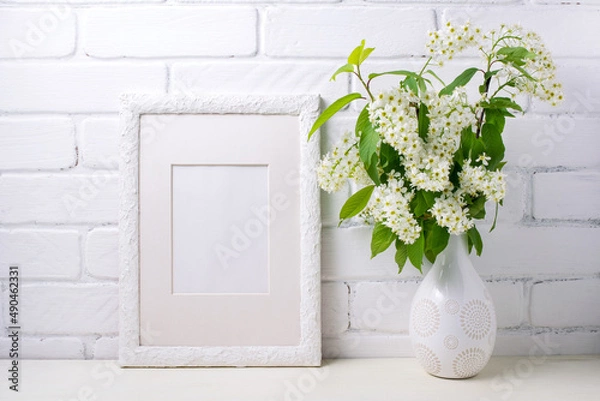 Fototapeta White frame mockup with blooming bird cherry in the decorated vase