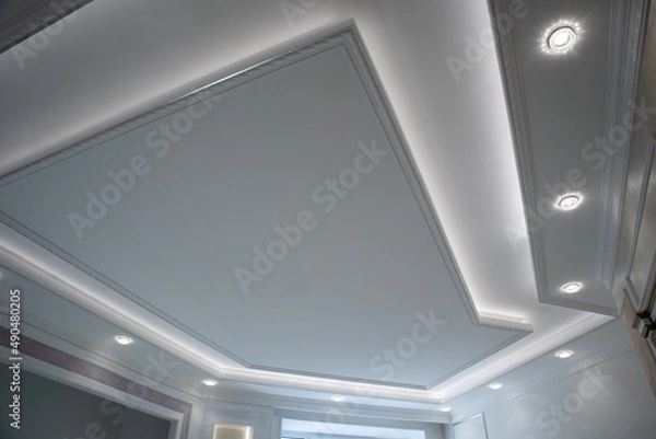 Fototapeta Antique-style interiors with plaster stucco on the walls. Multilevel complex plasterboard ceilings. 