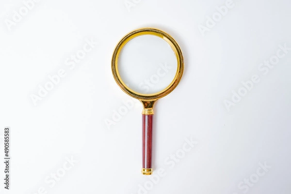 Fototapeta golden magnifying glass isolated on white background with copy space