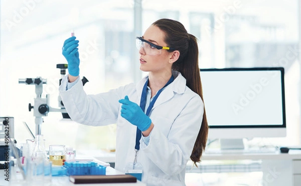 Fototapeta Here it is. Cropped shot of a focused young female scientist mixing chemicals together inside of a laboratory during the day.