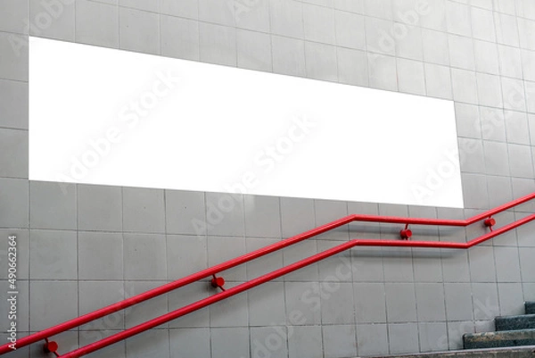 Obraz Long white empty commercial advertising poster located on concrete wall over red handrail near underground entrance