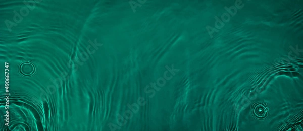 Fototapeta Transparent dark green clear water surface texture with ripples and splashes. Abstract summer banner background Water waves in sunlight with copy space Cosmetic moisturizer micellar toner emulsion