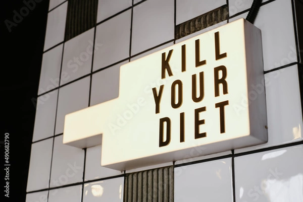 Fototapeta Illuminated sign on the wall indoors, saying "Kill your diet"