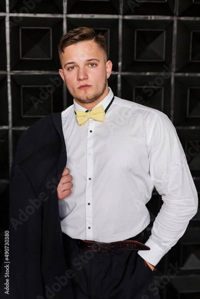 Fototapeta Stylish attractive young man, employee, future generation of businessman on black background.