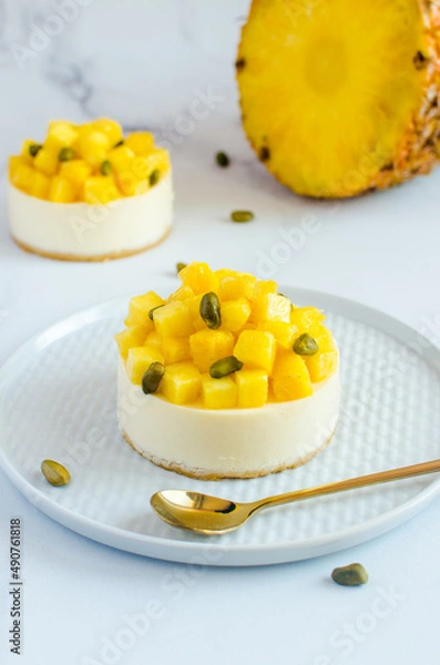 Obraz mini cheesecakes with pineapple and pistachios on a light background