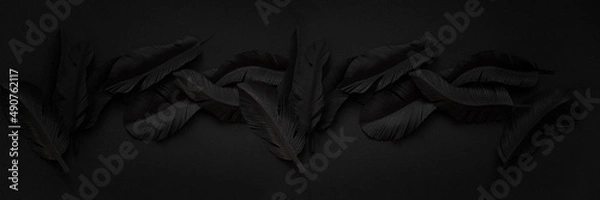 Fototapeta Details of black feathers cut out of paper, abstract dark background