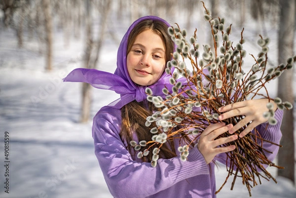 Fototapeta On a sunny spring day, a young girl walks, travels through the forest, collects willow for the Easter holiday. The girl walks among the birches, collects willows, rejoices, laughs, the Easter holiday.