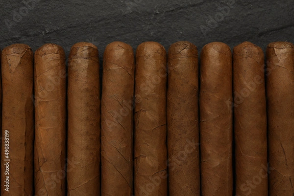 Fototapeta Many cigars on black table, flat lay