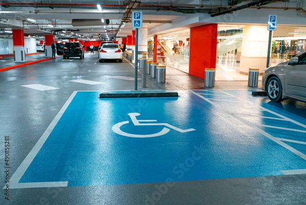 Fototapeta Interior of the new underground garage and a modern building construction with parking places for disabled.