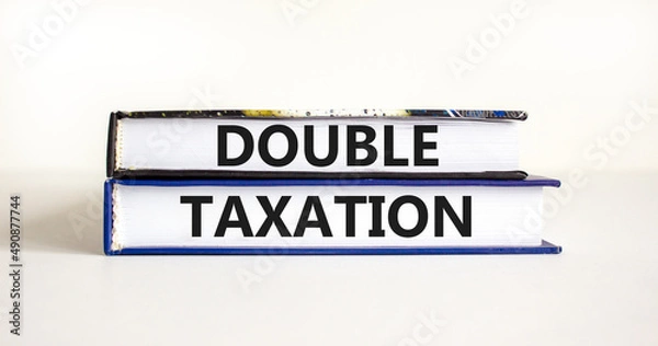 Fototapeta Double taxation symbol. Concept words Double taxation on books on a beautiful white table white background. Business tax and double taxation concept, copy space.