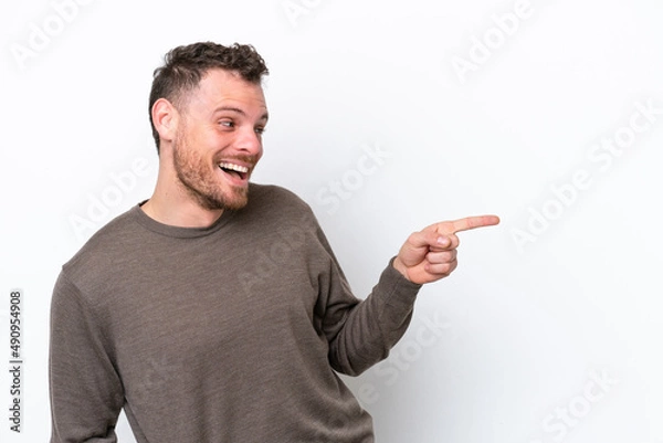 Fototapeta Young Brazilian man isolated on white background pointing finger to the side and presenting a product