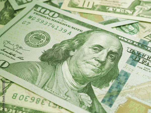 Fototapeta American paper money. A $100 bill with focus on eyes of Benjamin Franklin. US banknotes close-up. Business economy and the USA dollar. Light green tinted background. Macro