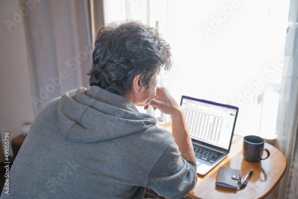 Obraz パソコンを見ながら考え込む男性