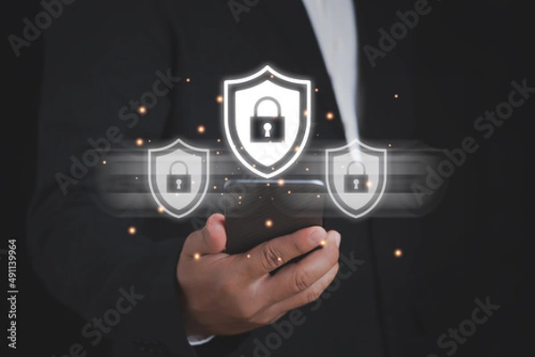 Fototapeta Smartphone security concept. Hand-holding Smartphone with glowing antivirus interface.