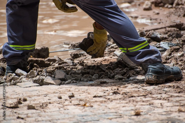 Obraz construction worker moving stone debris by hand