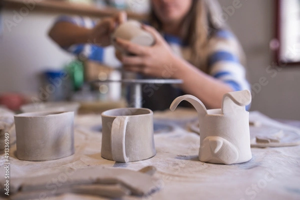 Obraz woman making ceramic handicrafts on a table