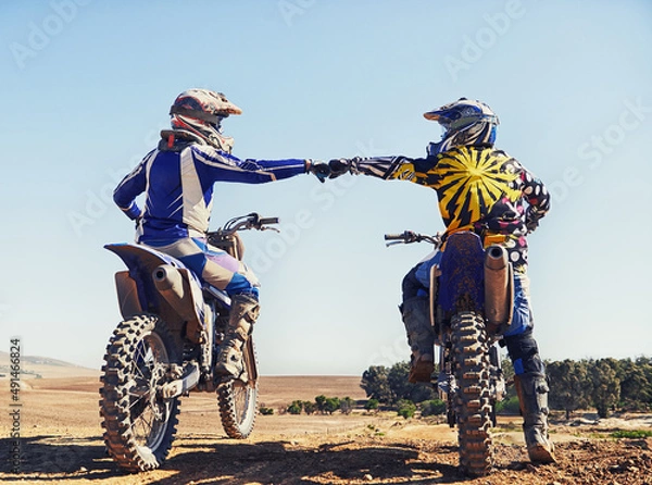 Obraz Time to rip up this track. Two motocross riders bumping fists before a race.
