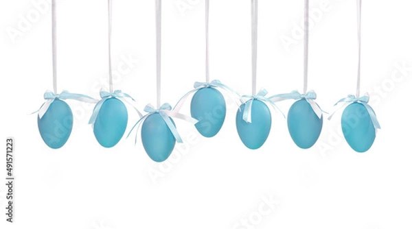 Fototapeta Seven blue Easter eggs hanging on white ribbons with a small bow isolated on a white background. Monochrome Easter eggs.