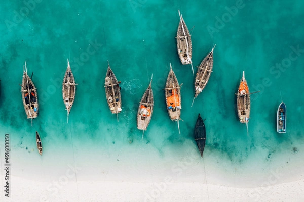 Fototapeta Top view or aerial view of Beautiful crystal clear water and white beach with long tail boats in summer of Zanzibar island