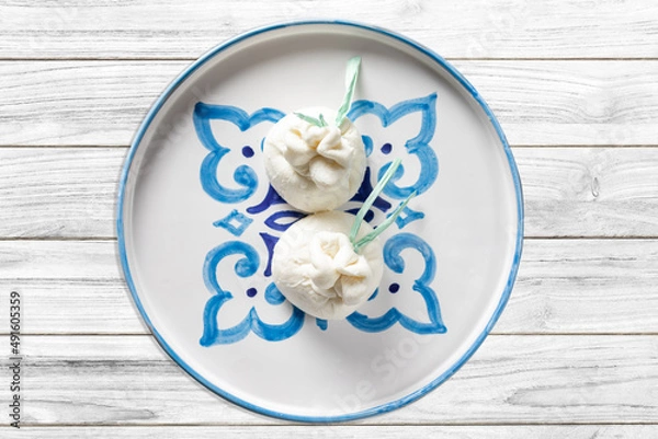 Obraz Burrata latticini della regione Puglia a base di mozzarella su tavolo rustico in legno	