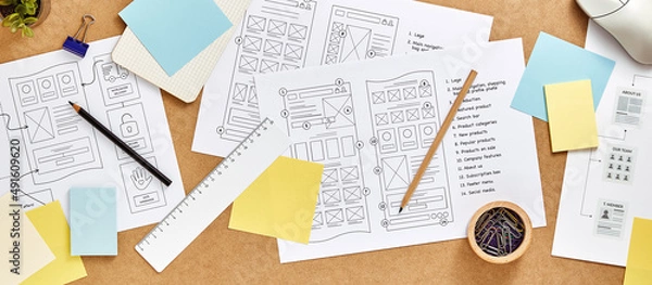 Obraz Web design concept banner. User experience designer desk with numerous website wireframe sketches and sitemap. Top view