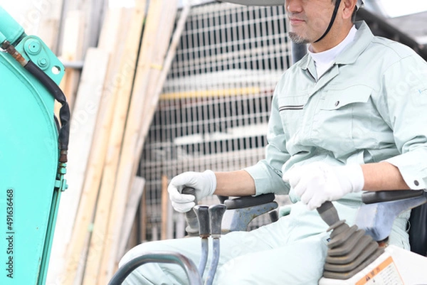 Fototapeta 工事現場で重機に乗る作業員の男性