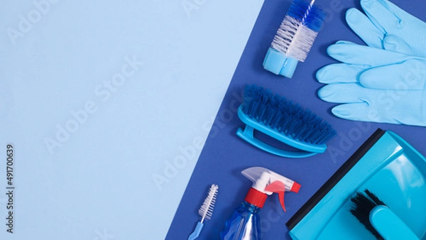Fototapeta Cleaning tools on deep and pastel blue background with copy space. Flat lay