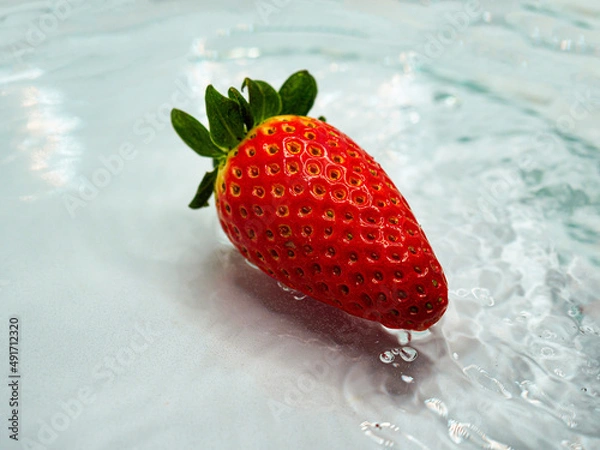 Obraz Red strawberry fruit in flowing water on bright background