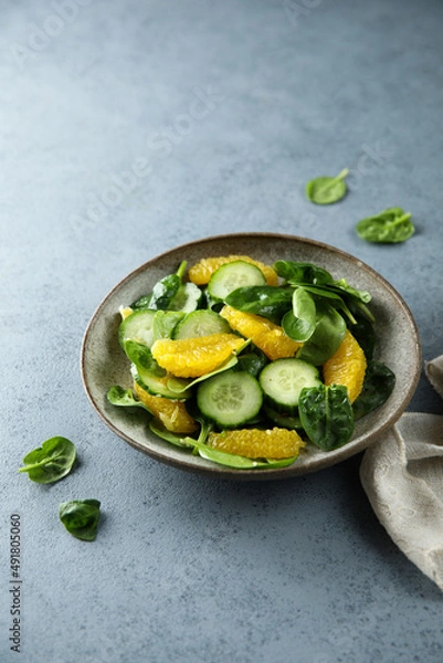 Fototapeta Healthy spinach salad with orange and cucumber