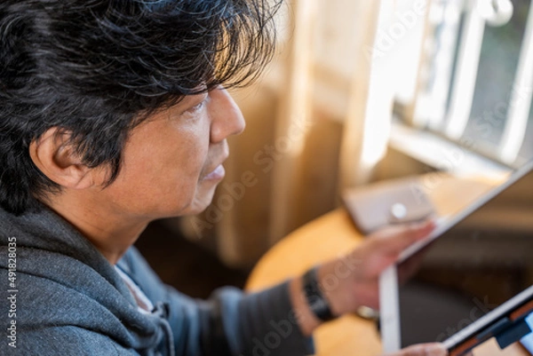 Fototapeta タブレットを操作している中年男性