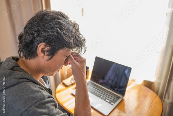 Obraz 疲れた目をマッサージしているリモートワーク中の男性