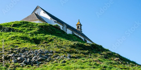 Obraz Carnac,France;February 26, 2022:Tumulus Saint Michel and its chapel, a site located in Morbihan in Brittany, the town is known for its alignments of 2,934 menhirs.