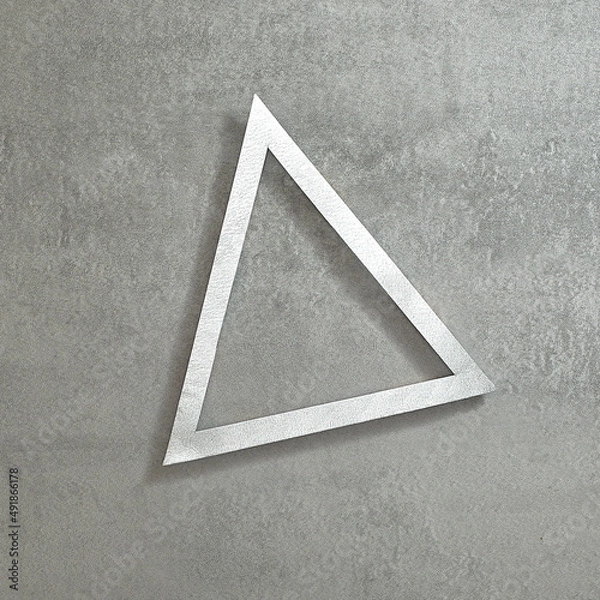 Fototapeta Simple triangular silver frame on a concrete gray background. Text space. Top view. Minimal style.