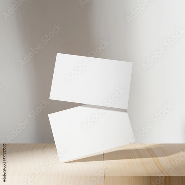 Fototapeta Blank business cards mockup on wooden table. Sunny shadow on wall background. 3D illustration rendering.