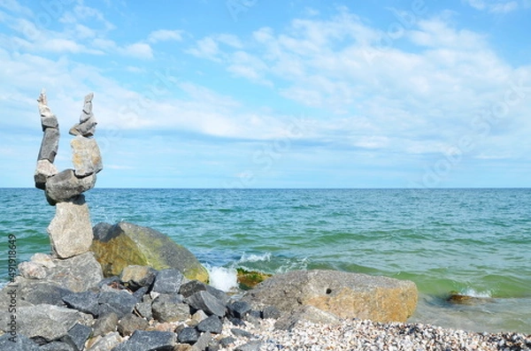 Fototapeta a figure of balancing stones on the seashore. stone beach. background. postcard