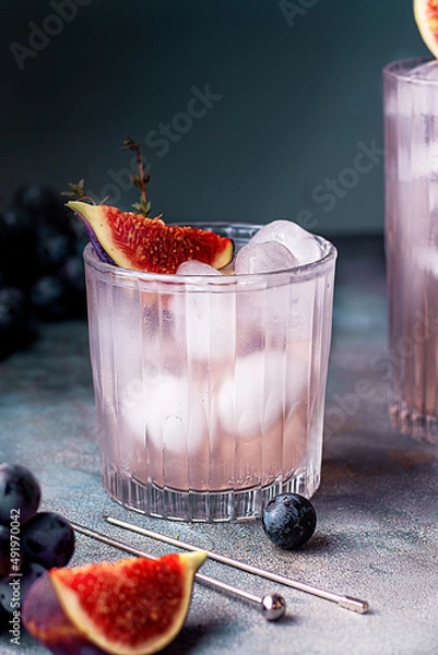 Fototapeta non alcoholic beverage with ice, figs and thyme garnish