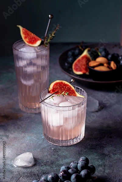Fototapeta non alcoholic beverage with ice, figs and thyme garnish