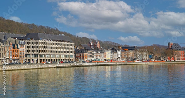 Fototapeta Liege, Belgium - March 5. 2022: View over river maas on historical waterfront houses against blue winter sky