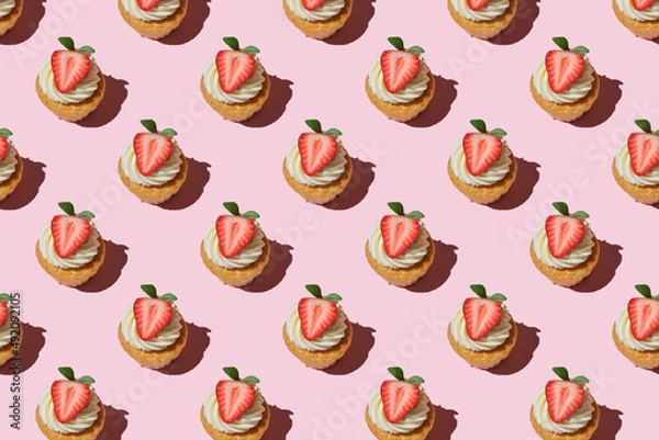 Obraz Pattern made of home cookies with strawberries and cream on a pink background. cupcake with big strawberry on top. Repeating  homemade cookies with strawberries and cream pattern. Flat lay style.