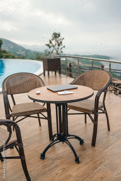 Fototapeta A wooden table on it is a laptop, phone and wireless headphones. Table with modern gadgets