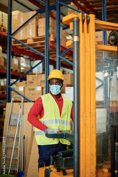 Fototapeta Worker in uniform working on warehouse