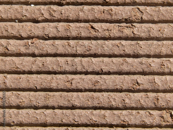 Fototapeta Close-up of a decking made of Wood-Polymer Composite, abstract textured brown background. Macrophotography of the polymer board texture. wpc material for the construction of terraces