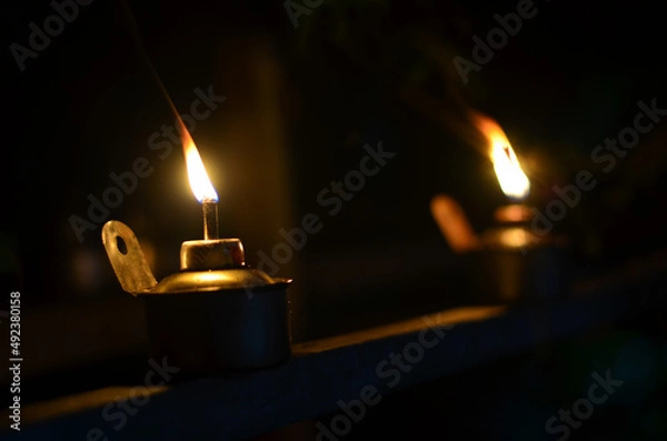 Fototapeta Traditional kerosene lamp light  also known as pelita isolated in a dark background.