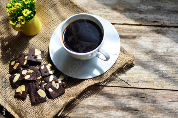Fototapeta Cup of coffee and tasty cookies on wooden background. Tea time and breakfast concept.
