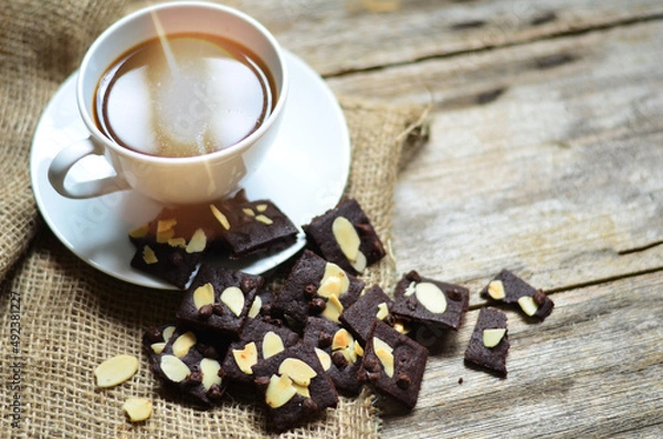 Fototapeta Cup of coffee and tasty cookies on wooden background. Tea time and breakfast concept.